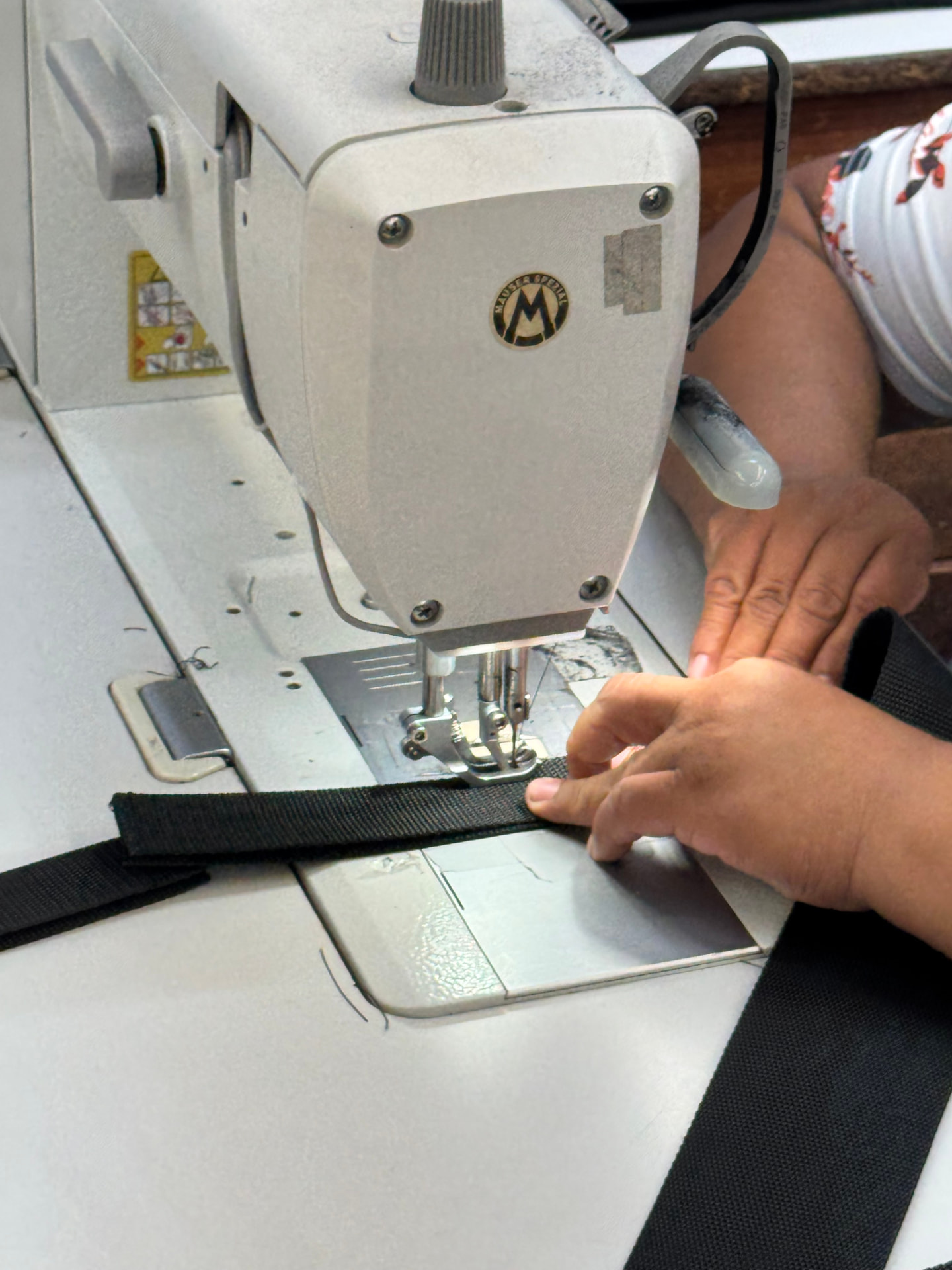 Close-up of black webbing strap being double-stitched