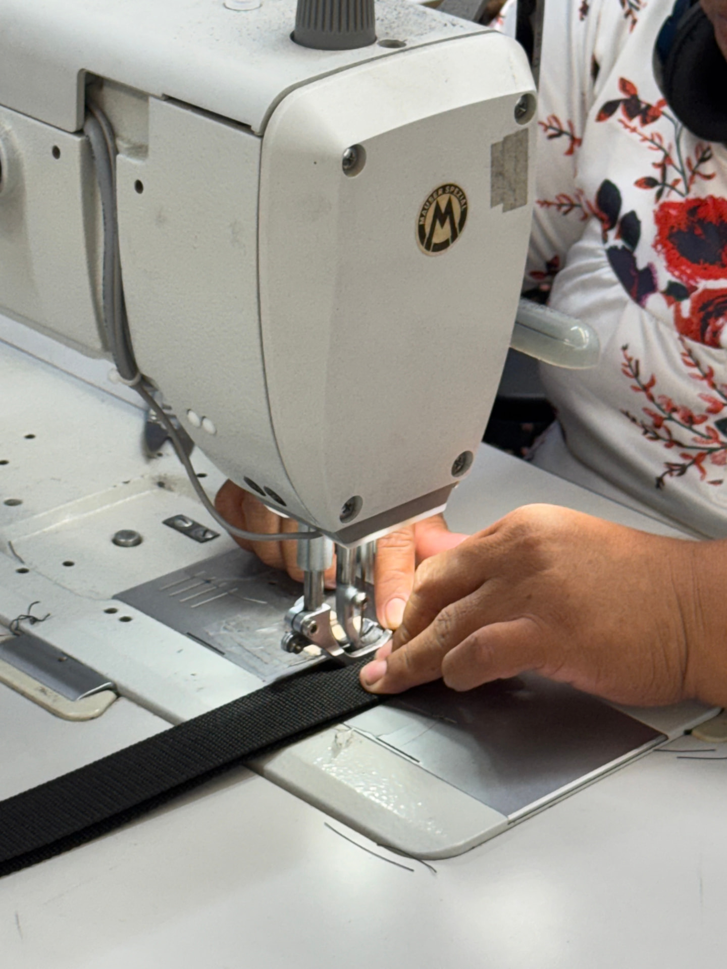 Operator stitching heavy black webbing strap on a Mauser Spezial industrial machine